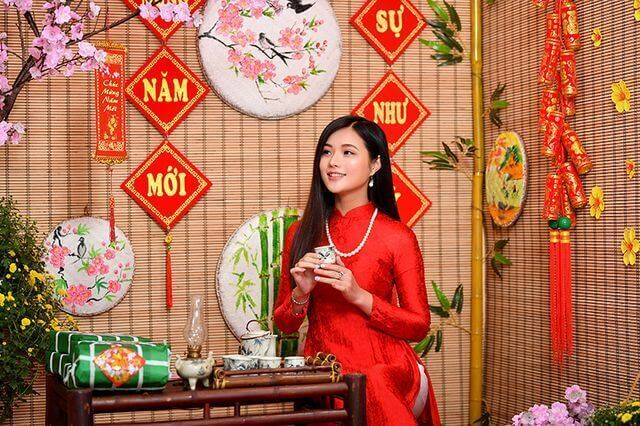 Tạo dáng chụp hình Tết bên cạnh bánh trưng