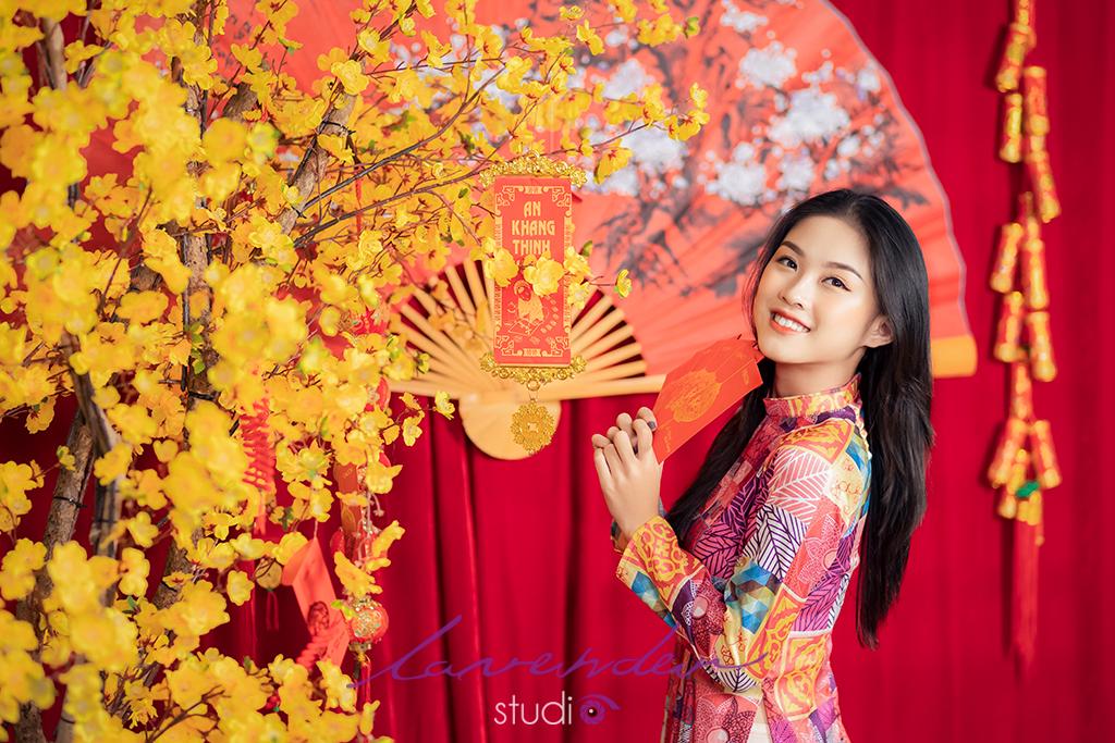 Tạo dáng chụp hình Tết bên cạnh câu đối